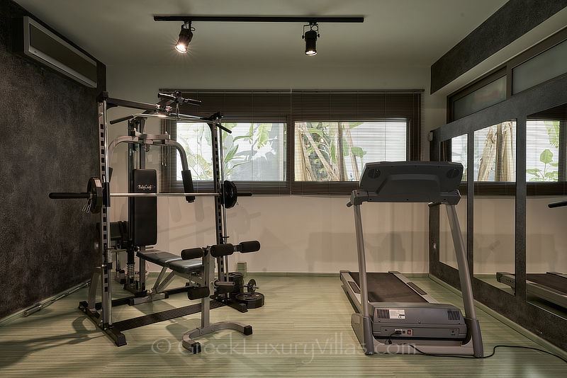 Voll ausgestattetes Fitnessstudio der modernen Luxusvilla mit beheiztem Pool und Blick auf die Bucht von Elounda