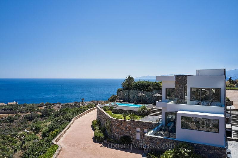 Luftaufnahme der modernen Luxusvilla mit beheiztem Pool und Blick auf die Bucht von Elounda auf Kreta