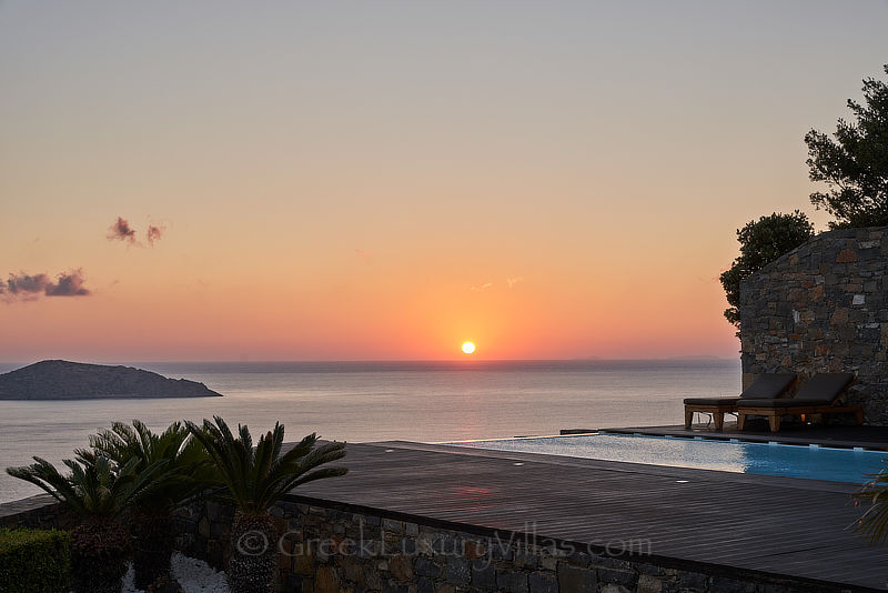 Sonnenuntergang in der modernen Luxusvilla mit beheiztem Pool und Blick auf die Bucht von Elounda