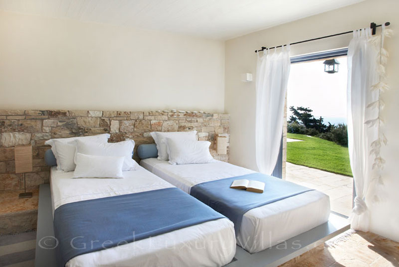 A twin bedroom in a beachfront villa with a pool in Paxos