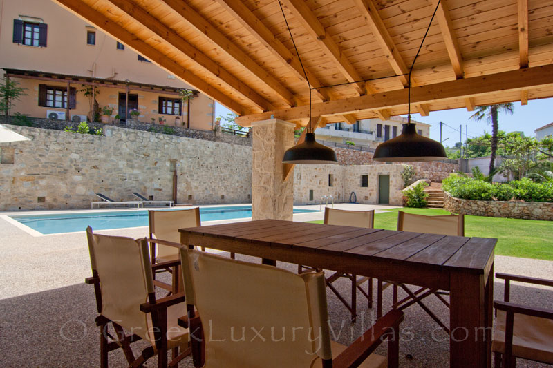 Outdoor dining area of a luxury villa with a pool in a traditional village