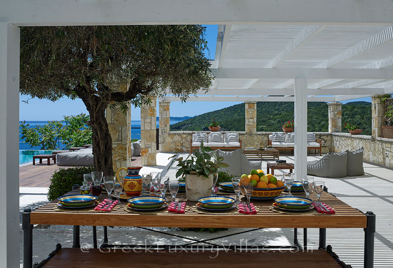 Outdoor dining area at a luxury villa with a heated pool in Sivota