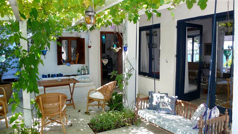 A shaded outdoor lounge of a beachfront villa in Paxos