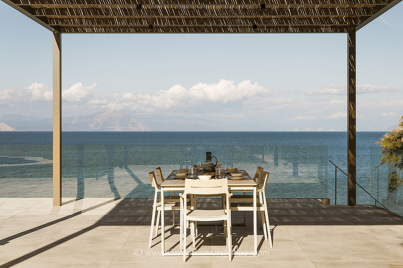 outdoor dining at beachfront villa with pool